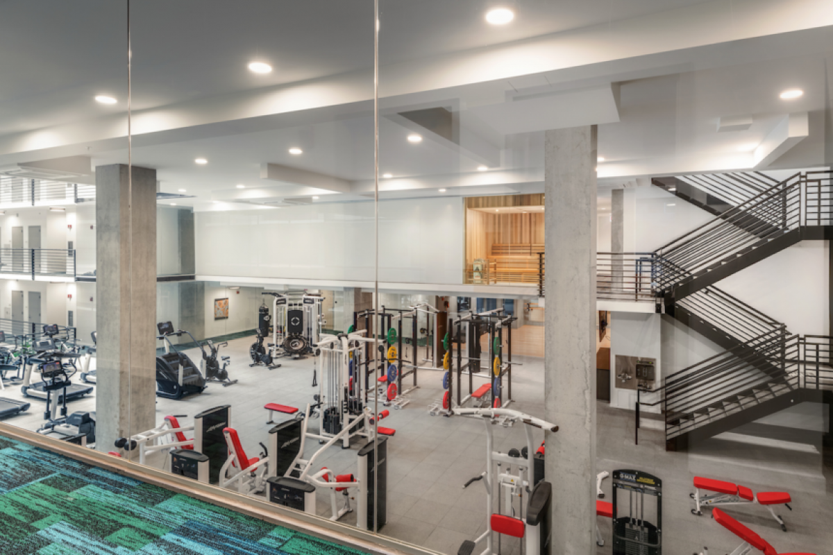 Optima Lakeview® Apartments in Chicago, IL Modern gym with various fitness machines and cardio equipment, designed for current trends to support a healthier life in a spacious, well-lit area.