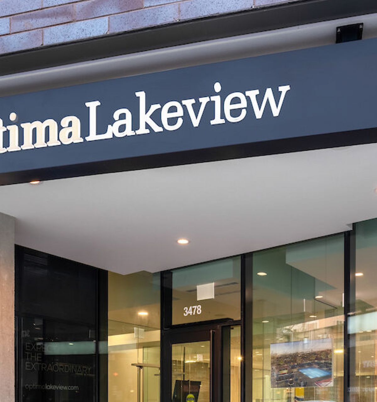 Optima Lakeview® Apartments in Chicago, IL Entrance of a modern building with “Optima Lakeview” above glass doors—perfect for Yoga or Pilates enthusiasts seeking luxury living.