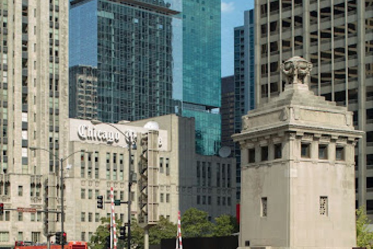 Optima Lakeview® Apartments in Chicago, IL People walk on a downtown Chicago street, showcasing the city’s architectural diversity with modern and historic skyscrapers behind them.