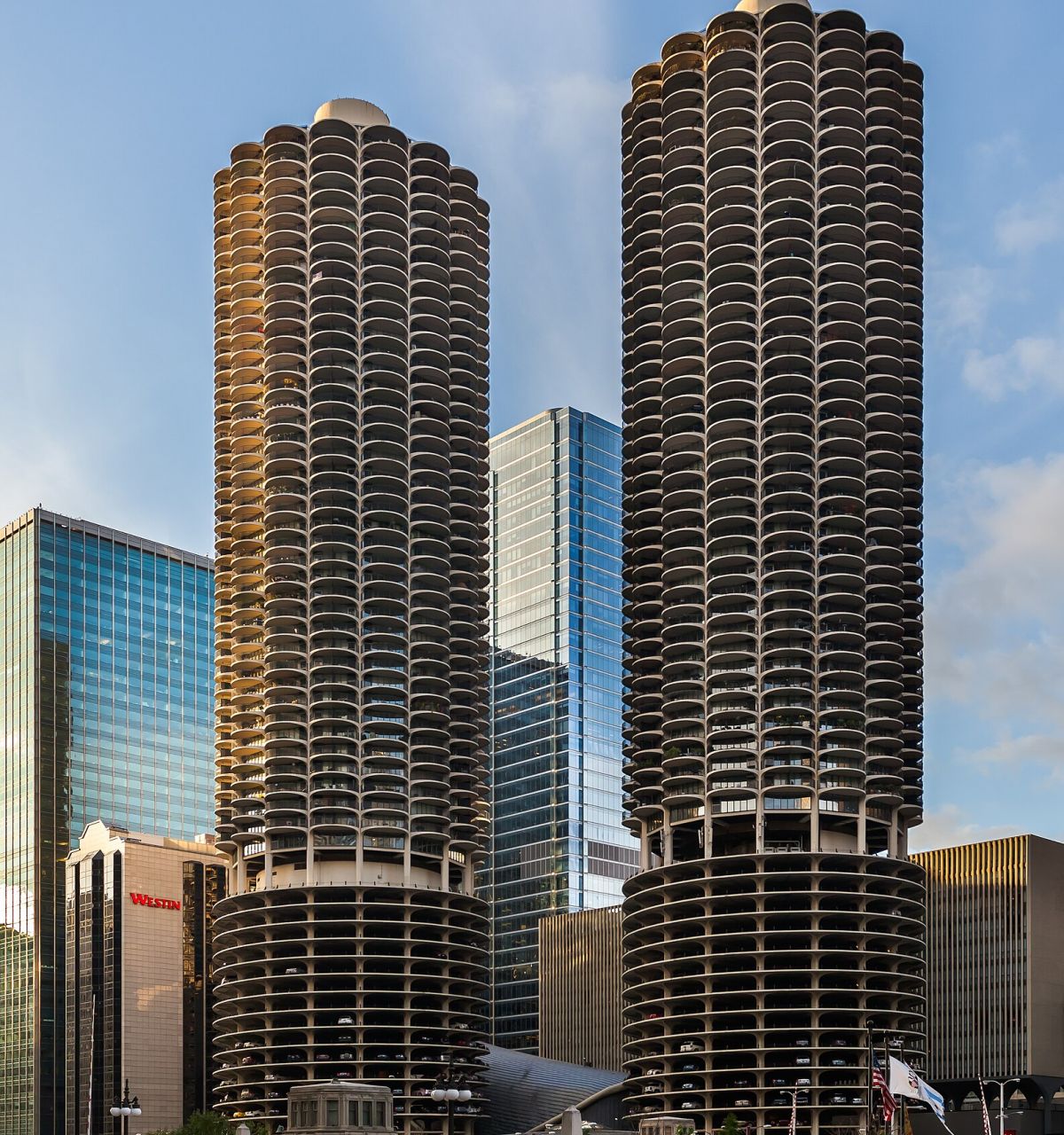 Optima Lakeview® Apartments in Chicago, IL Two tall, cylindrical towers with scalloped balconies rise among Chicago's modern skyscrapers in a striking cityscape.