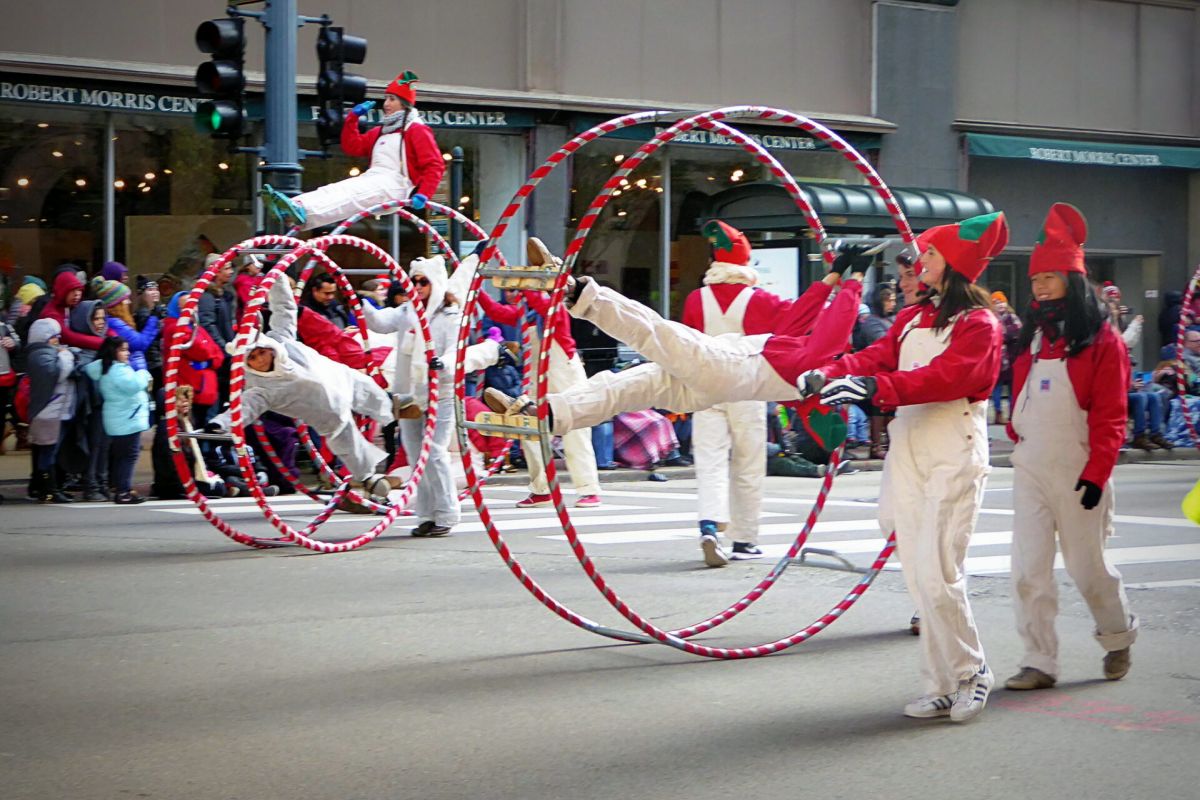 Optima Lakeview® Apartments in Chicago, IL Four performers spin inside red-and-white hoops during the Chicago Thanksgiving Parade, watched by a crowd in winter clothes.