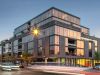 Optima Lakeview® Apartments in Chicago, IL Modern glass and brick apartment building on a busy city street at sunset with light trails from cars.