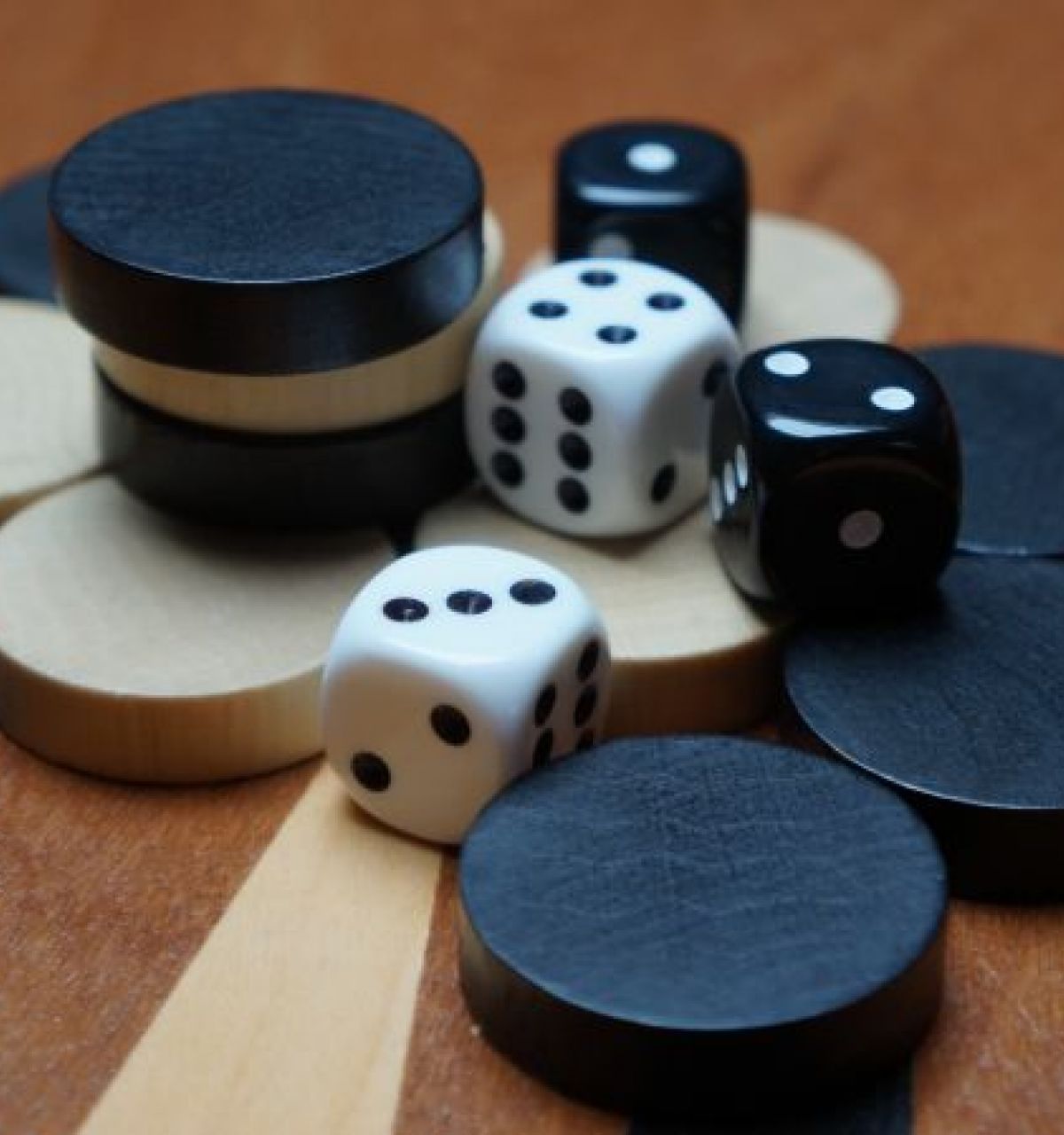 Optima Lakeview® Apartments in Chicago, IL Black and white backgammon pieces and dice scattered on a wooden board highlight the classic game’s timeless appeal.