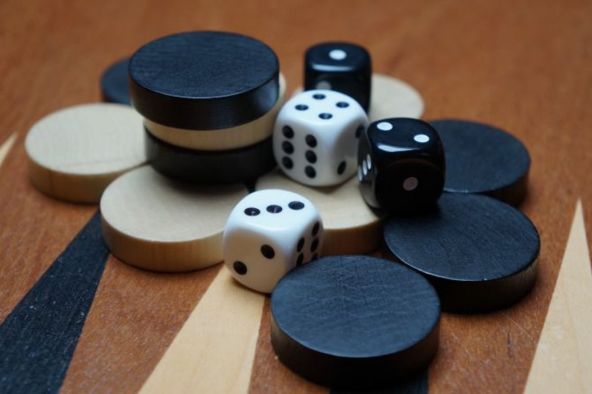 Optima Lakeview® Apartments in Chicago, IL Black and white backgammon pieces and dice scattered on a wooden board highlight the classic game’s timeless appeal.