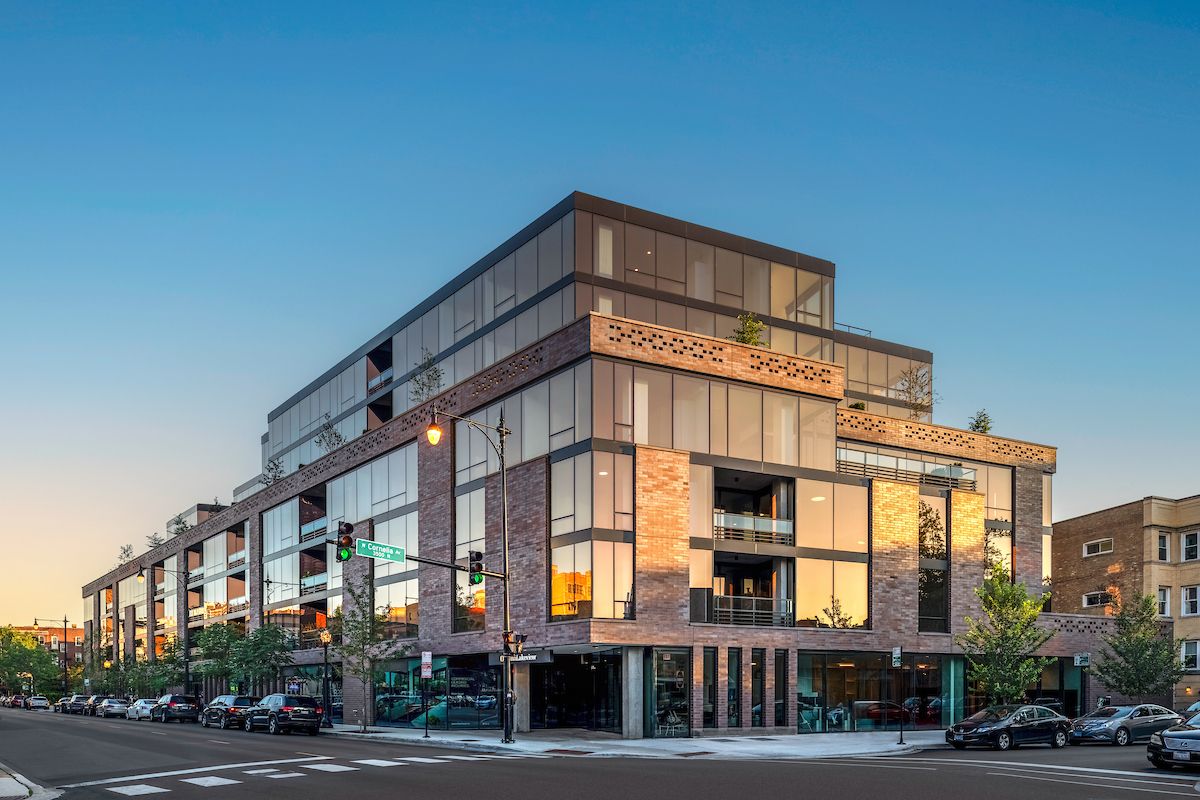 Optima Lakeview® Apartments in Chicago, IL Modern multi-story building with common features of the Optima Portfolio, large windows, brick accents, and lively street-level shops.