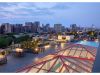 Optima Lakeview® Apartments in Chicago, IL Rooftop patio with seating, fire pits, pool, and city skyline view at sunset—exclusively for Optima Residents to rent and enjoy.