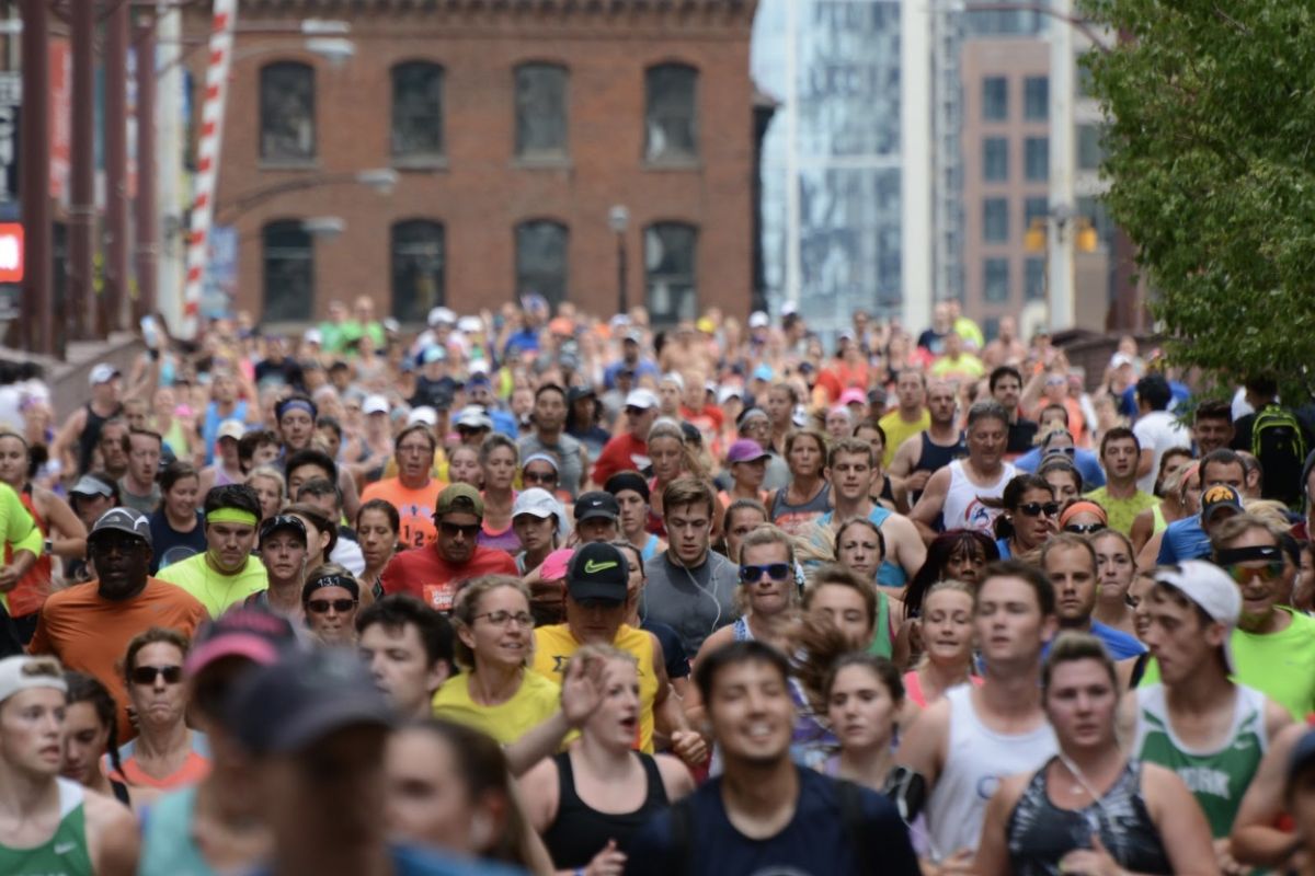 Optima Lakeview® Apartments in Chicago, IL A large crowd of runners in colorful outfits participate in the Chicago Marathon on a busy city street.