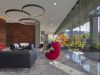 Optima Lakeview® Apartments in Chicago, IL Modern lobby with floor-to-ceiling windows, black sofas, a red chair, and wood accent walls illustrates clever architecture palettes.