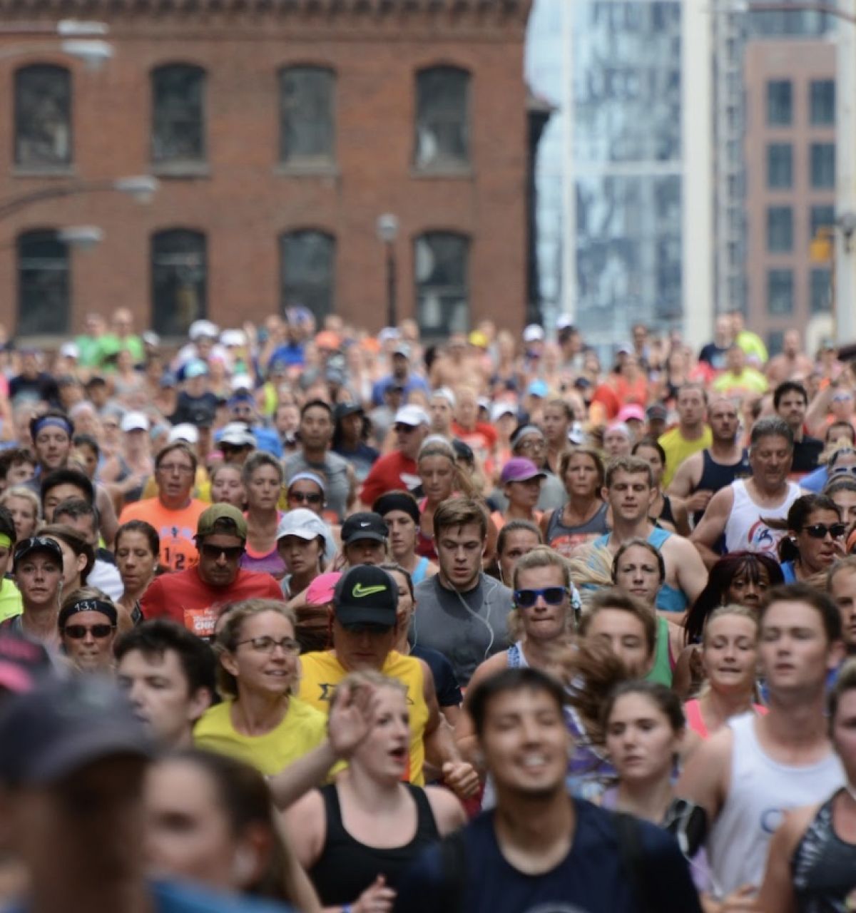 Optima Lakeview® Apartments in Chicago, IL A large crowd of runners in colorful outfits participate in the Chicago Marathon on a busy city street.