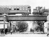 Optima Lakeview® Apartments in Chicago, IL Historic black-and-white photo of a train riding the rails on the Chicago “L” above a bustling street scene.