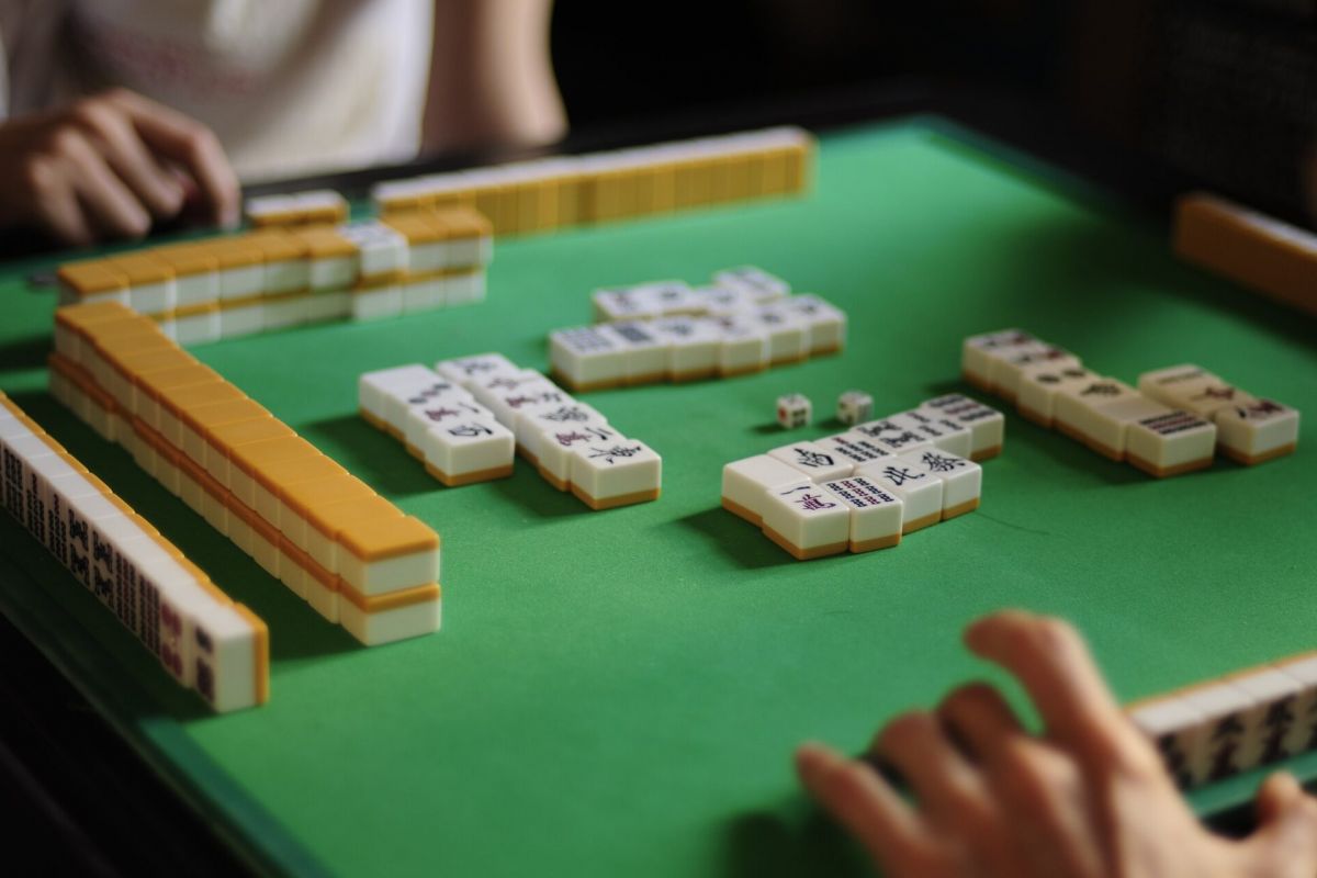 Optima Lakeview® Apartments in Chicago, IL Two people enjoy a game of mahjong at a Chicago table, reflecting the vibrant spirit of local Mahjong Meetups.