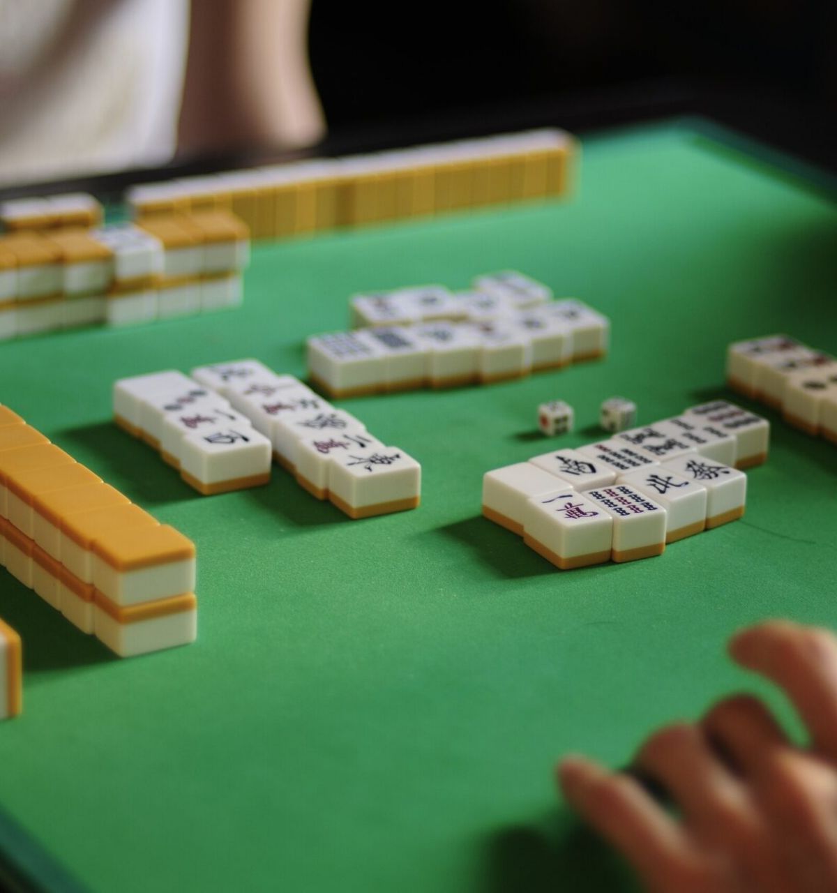 Optima Lakeview® Apartments in Chicago, IL Two people enjoy a game of mahjong at a Chicago table, reflecting the vibrant spirit of local Mahjong Meetups.