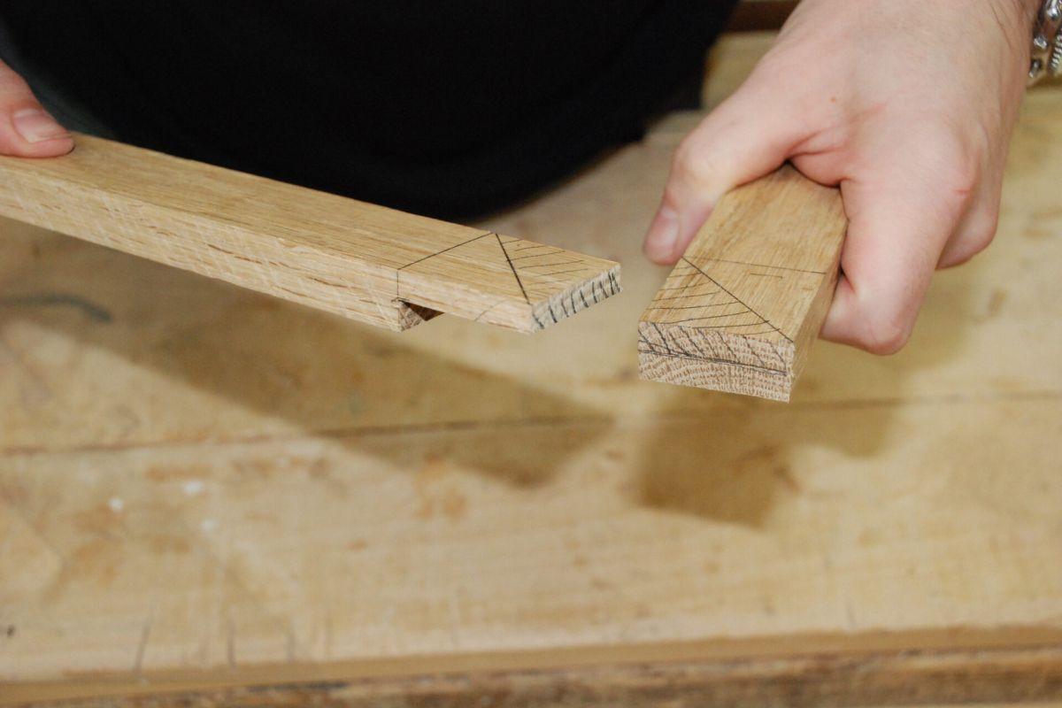 Optima Lakeview® Apartments in Chicago, IL Two hands hold dovetail-jointed pieces, showcasing skills learned at Chicago School of Woodworking classes.