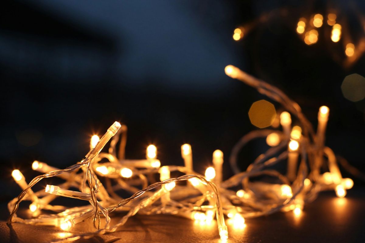 Optima Lakeview® Apartments in Chicago, IL Close-up of glowing yellow string lights adds a cozy touch to home decor against a dark, blurred background.