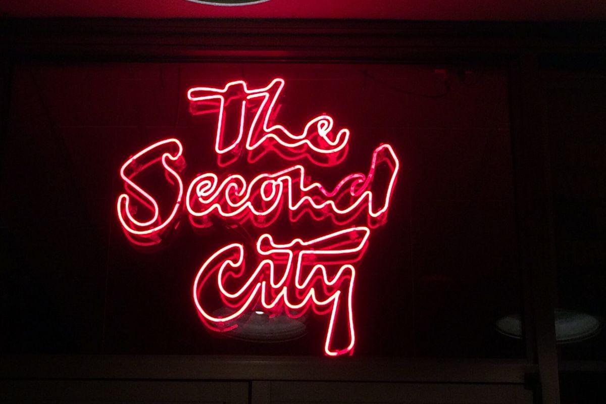 Optima Lakeview® Apartments in Chicago, IL Red neon sign reading "The Second City" glows, hinting at its Chicago origins against a dark background.