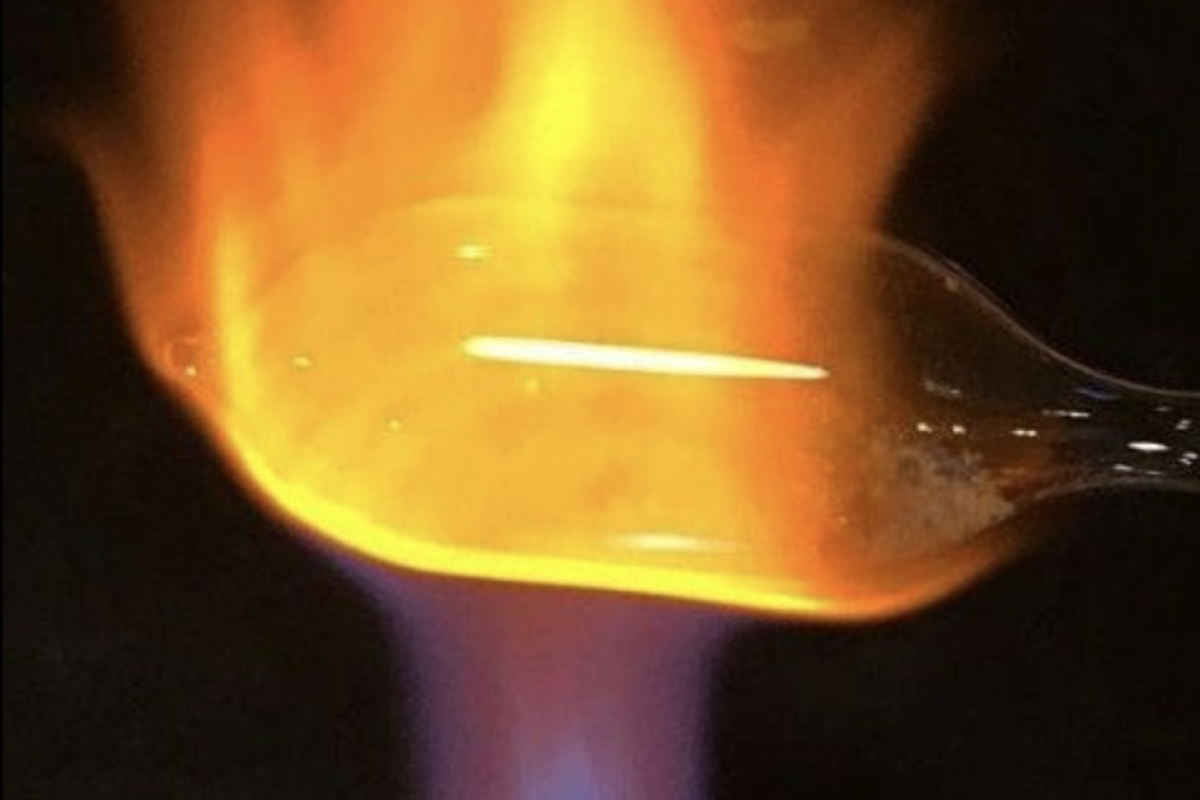 Optima Lakeview® Apartments in Chicago, IL A plastic spoon melting and burning over a blue and orange flame, reminiscent of Chicago glass blowing artistry.