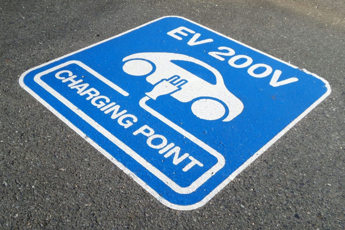 Optima Lakeview® Apartments in Chicago, IL Blue sign on pavement marks EV Parking: "EV 200V Charging Point" with electric car and plug icon, part of the Sustainability Series.