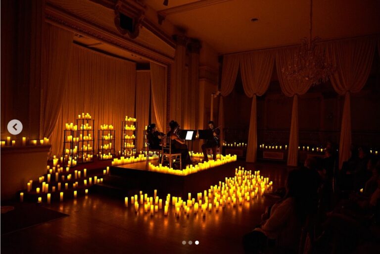 Optima Lakeview® Apartments in Chicago, IL A string quartet performs at Candlelight Concerts on a candlelit stage in a dimly lit, elegant room with draped curtains in Chicago.