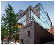 Optima Lakeview® Apartments in Chicago, IL Modern brick and glass building on a city street with trees and people walking nearby.